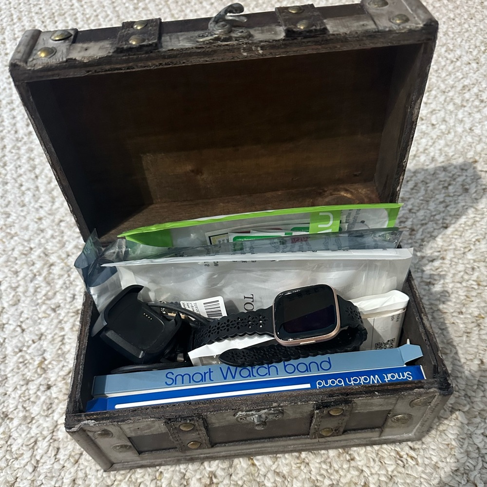 Fit Bit Versa 2 watch, charger, and accessories.